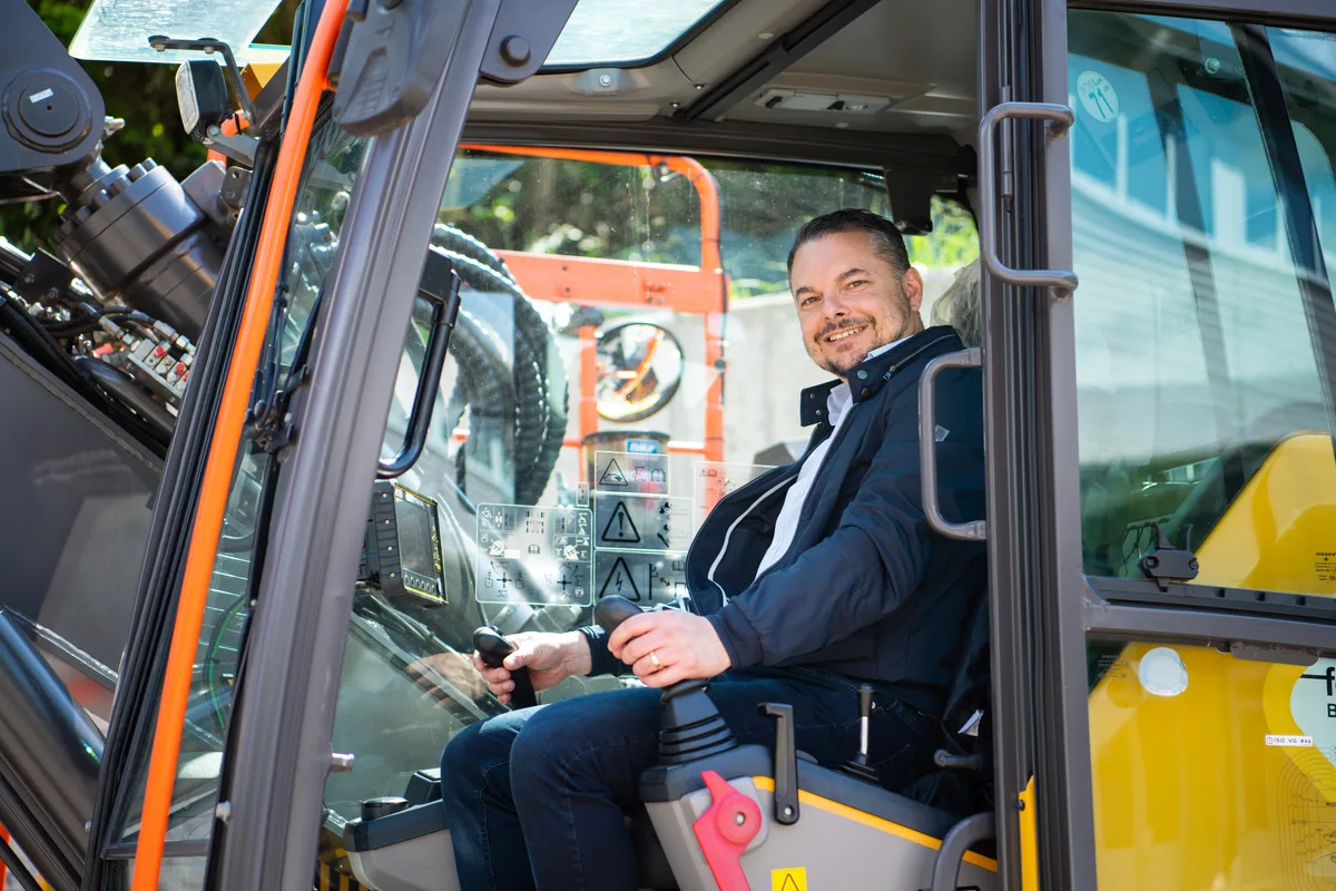 Roger Hess (Die Mitte), hier beim Spatenstich für den Energieverbund Rüti Zentrum, ist überrascht über das Aus zur Fernwärme. (Archiv) Ein Mann sitzt in einem Bagger.